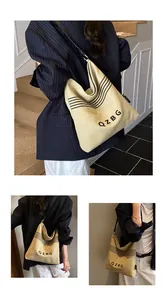 Detail showing high-quality canvas fabric with black letter print and metal buckles on the bag