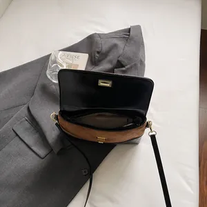 Elegante borsa a tracolla bicolore con patta in pelle nera e camoscio marrone trapuntato