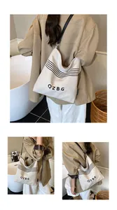 Detailed macro view of the minimalist beige canvas bucket bag with black QZBG lettering