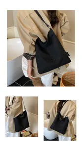 Detail shot of black canvas bucket bag featuring QZBG embroidered lettering and side label