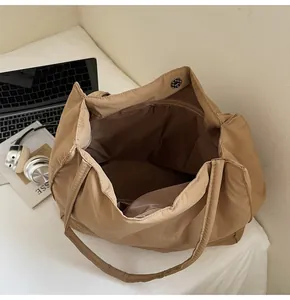 Detail view of khaki nylon tote bag interior with magnetic snap and laptop space