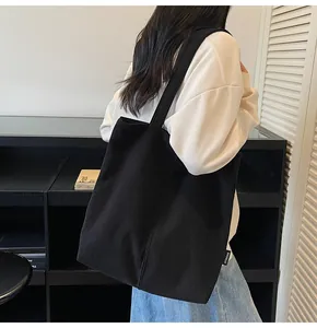 Close-up of black corduroy tote bag texture with minimalist side brand label