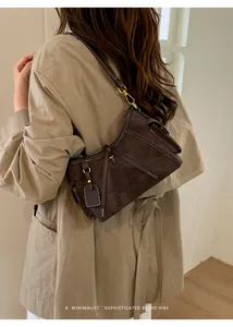 Brown suede minimalist shoulder bag with contrast stitching shown on model outfit