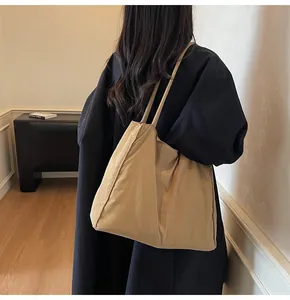 Detail view of large khaki canvas tote bag showing its natural drape and slim shoulder straps