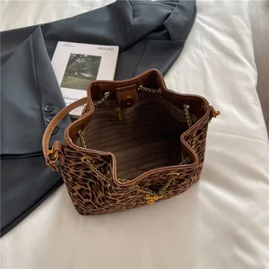 Minimalist leopard print bucket bag with gold chain and crossbody leather strap