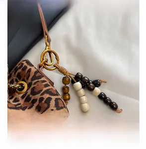 Detail of leopard print bucket bag with vintage wooden beads and metal hardware buckle