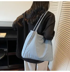 Rear view of a model wearing a large light blue canvas tote bag with long straps