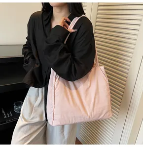 Close-up of pink large capacity canvas tote bag worn on shoulder by a model