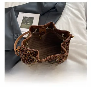 Detailed interior of leopard print bucket bag with metal chain drawstring and lining