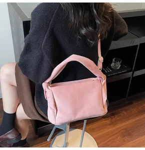 Detail of pink suede fabric shoulder bag with thick handle and adjustable strap buckle