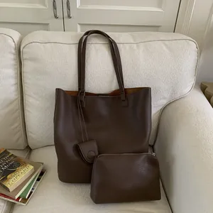 Detailed close-up of a dark brown bucket bag set with textured lychee grain leather finish