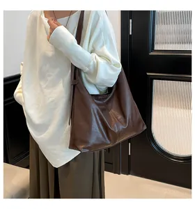 Detail of spacious dark brown hobo bag showing high-gloss synthetic leather and stitching
