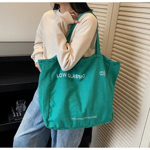 Gros plan détaillé d'un grand sac fourre-tout en toile verte avec broderie blanche