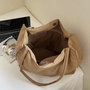 Minimalist khaki nylon tote bag interior with magnetic snap and zipper pocket