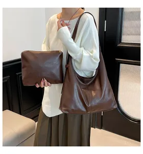 Detail view of dark brown oil wax leather tote bag and matching small pouch set