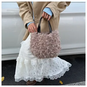Detail of soft dusty pink faux fur bucket bag with contrasting black leather handles