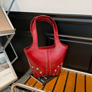 Retro red studded shoulder bag made of glossy leather with metallic ring accents