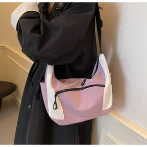 Detail of purple and white hobo bag with contrast stitching and nylon texture on model