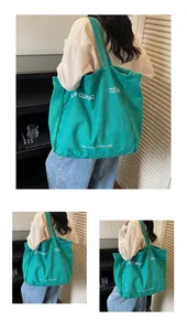 Vue détaillée du matériau en toile verte et du logo blanc sur le sac fourre-tout
