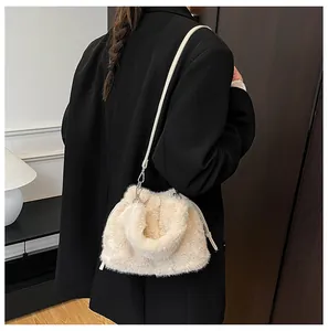 Detail of plush beige bucket bag texture with slim shoulder strap and metal hook