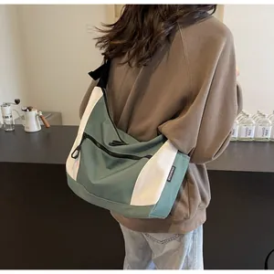 Detail view of large capacity canvas shoulder bag in contrast green and cream colors