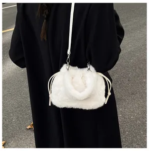 Detail of white faux fur bucket bag with drawstring and silver metal hardware accents
