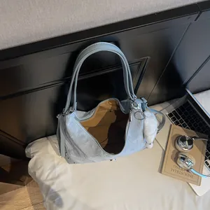 Light blue large capacity tote bag with pleated texture and plush heart charm on white bedding