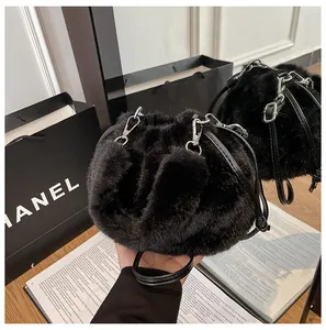 Detail of black faux fur bucket bag featuring plush texture and elegant leather strap