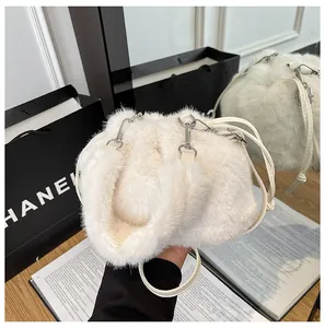 Close-up detail of white faux fur bucket bag with soft pleated texture and silver buckle
