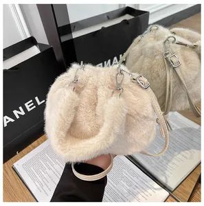 Close-up of plush beige bucket bag texture with leather strap and silver hardware