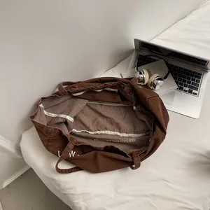Grand sac fourre-tout en toile marron avec lettrage blanc et poche intérieure zippée