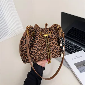 Leopard print bucket bag with gold chain drawstring and wooden bead charm accessory