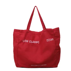Sac fourre-tout minimaliste en toile rouge avec double poignée et lettrage blanc brodé