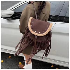Détails des rivets en étoile et franges sur un sac à dos vintage marron pour femme
