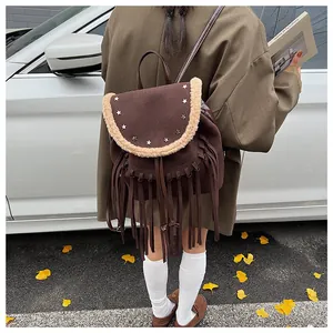 Détail du sac à dos bohème avec franges en cuir et rivets étoiles sur bordure en laine