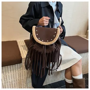 Vue détaillée du sac à dos en daim marron avec franges, rivets étoiles et bordure en laine