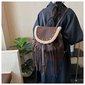 Détail du sac à dos marron à franges avec rivets étoiles et bordure en laine de mouton