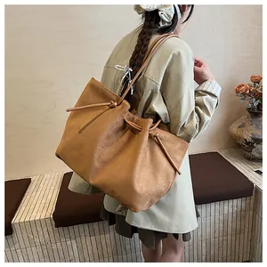 Detail of the vintage brown suede tote bag with drawstring knots in a lifestyle setting