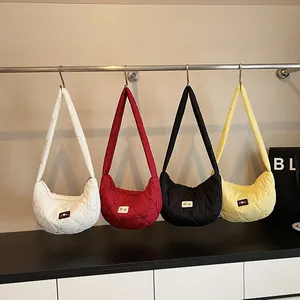 Quilted heart-shaped dumpling bags in white, red, black, and yellow hanging on a rack