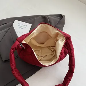 Red quilted dumpling bag with heart stitching and spacious beige lining