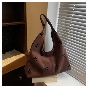 Detail view of coffee suede tote bag with laser-cut floral patterns and textured finish