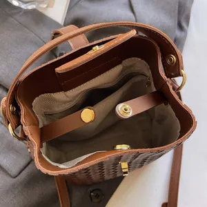 Deep brown woven bucket bag with interior gray lining and metallic magnetic closure