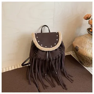 Détail du sac à dos marron à franges avec rivets étoiles et bordure en fourrure