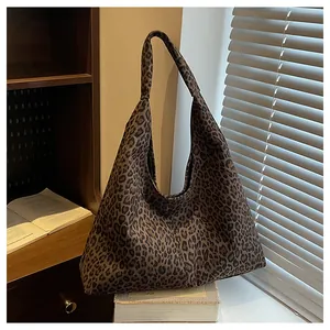 Detail shot of vintage leopard print tote bag with wide strap in warm interior setting
