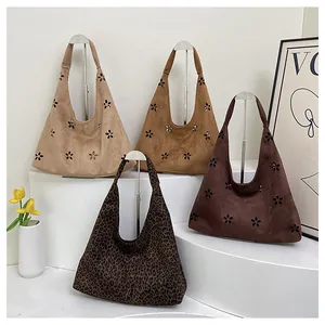 Detail of laser-cut floral pattern on high-capacity suede hobo shoulder bags in various colors
