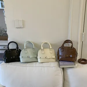 Minimalist shell-shaped handbags in four colors with bow detail and crossbody straps
