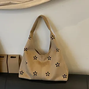 Chic beige faux suede tote bag with floral laser-cut patterns and hobo style shoulder strap