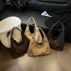 Minimalist hollow-out tote bags in suede and leopard print displayed in a retro room