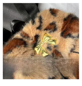Close-up of leopard faux fur backpack texture featuring a gold bow metallic buckle