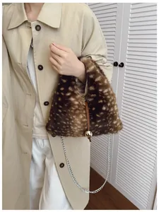 Detail of faux fur triangular bag with deer print texture and golden ball metal charm